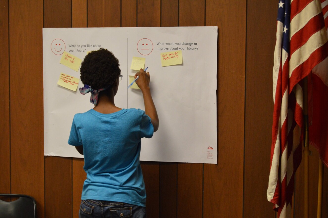 A community member posts feedback during a listening session in July at the Hyde Park branch.